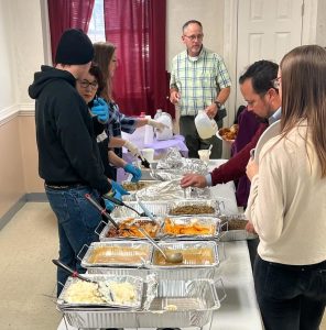 church members serving food and drinks at the monthly fellowship meal